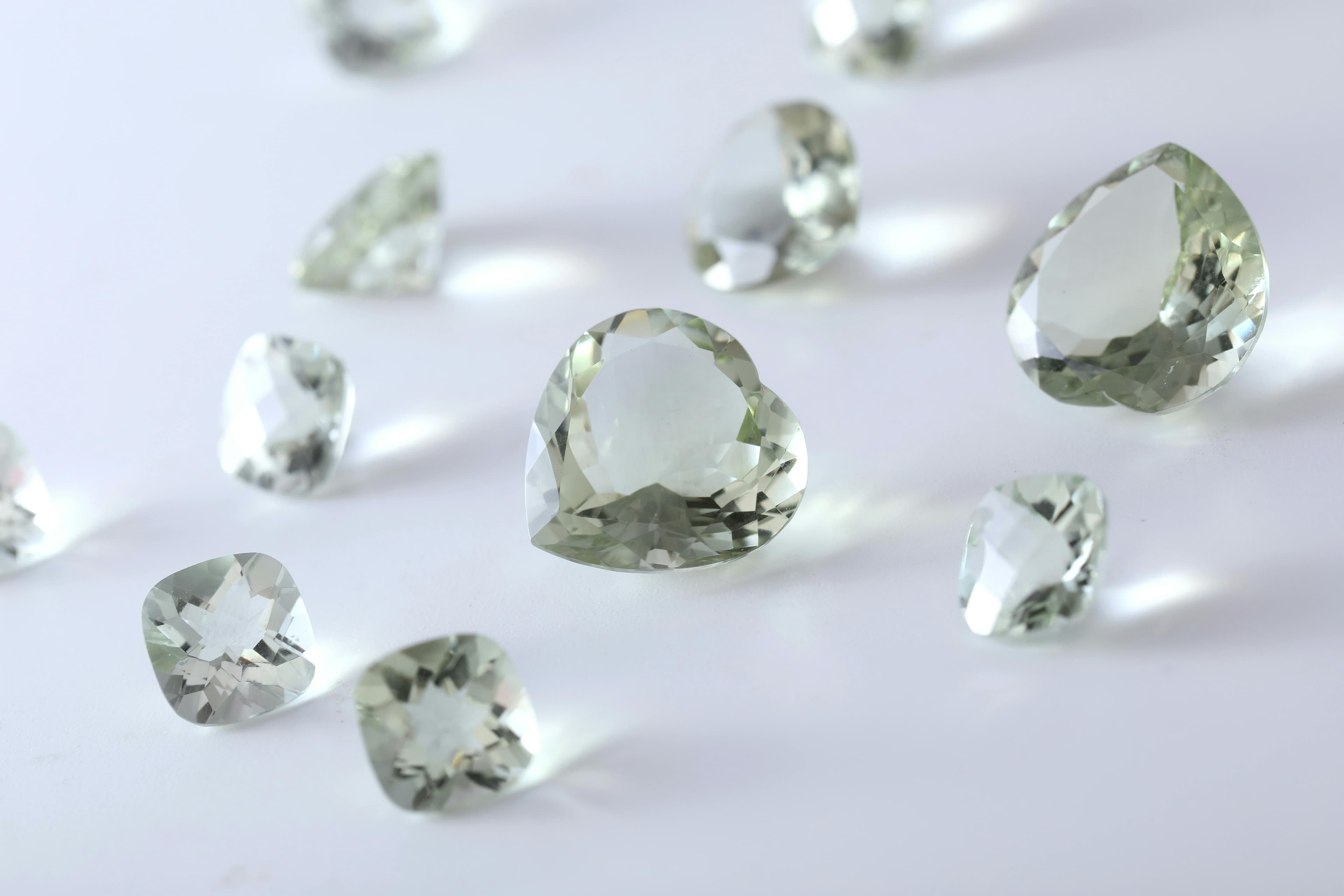 Pale faceted gemstones laid out on a white surface